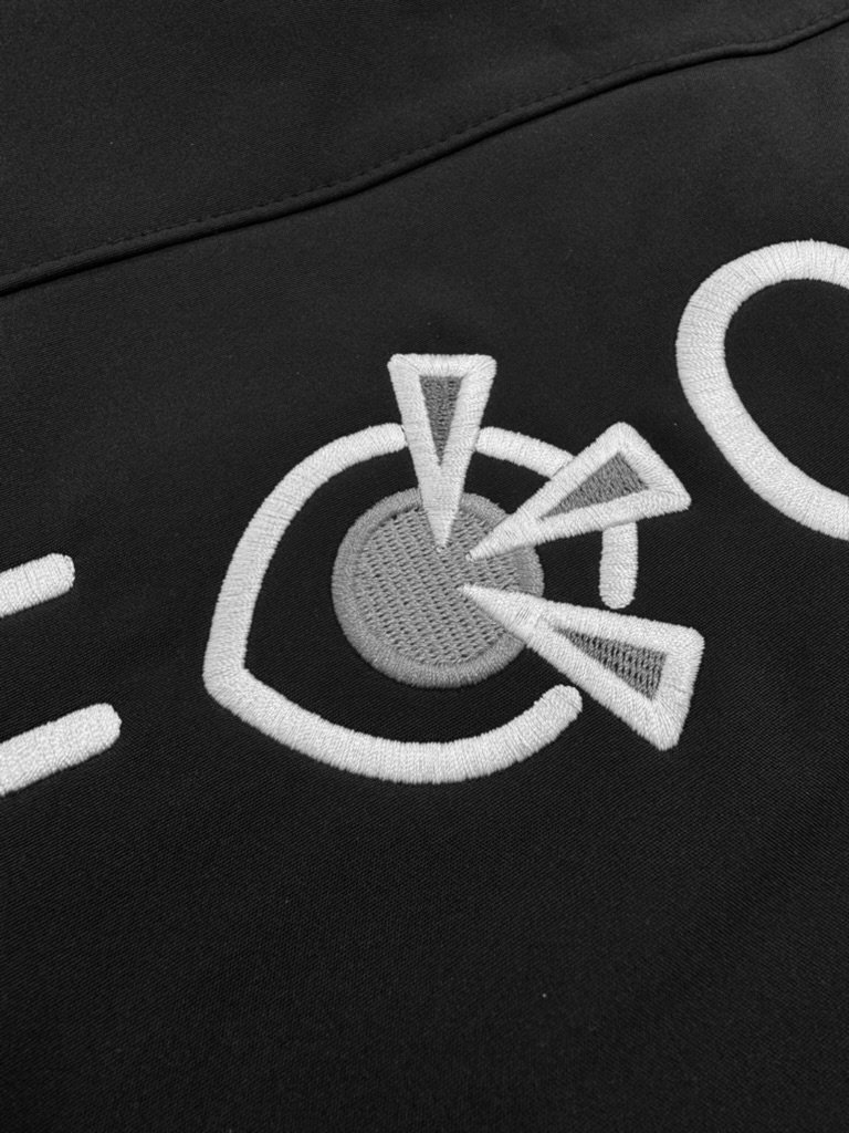 Detail van het Focus logo, close-up van steken in wit, blauw en oranje garen